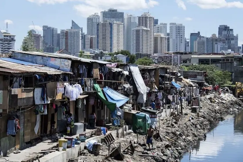 TOPSHOT - People living in a settlement walk about, as the skyline of Manila's financial district is seen in the background, on August 17, 2017.
The Philippine economy grew by 6.5 percent in the three months to June, likely one of the fastest in Asia, the government said on August 17, defying concerns over President Rodrigo Duterte's unconventional leadership. / AFP PHOTO / Noel CELIS (Photo credit should read NOEL CELIS/AFP/Getty Images)