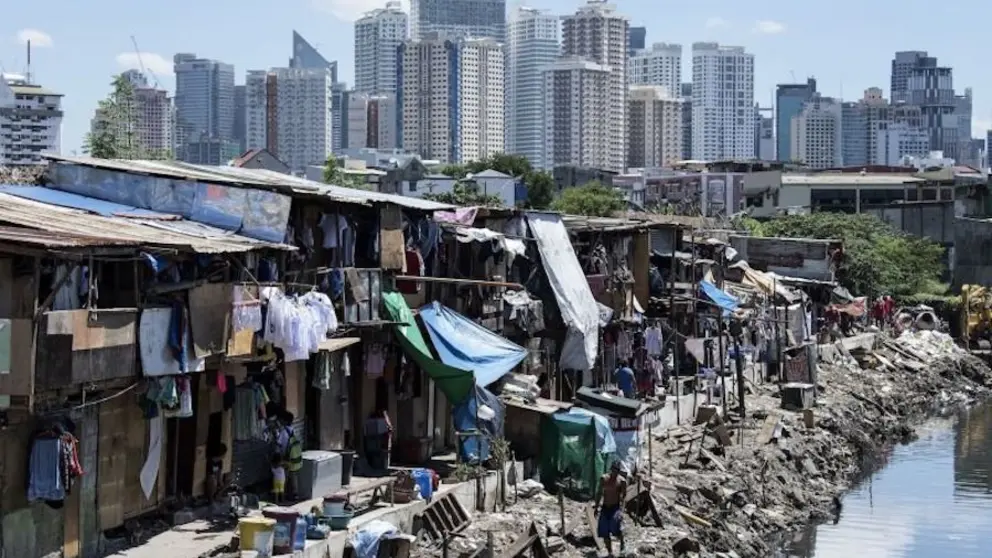TOPSHOT - People living in a settlement walk about, as the skyline of Manila's financial district is seen in the background, on August 17, 2017. 
The Philippine economy grew by 6.5 percent in the three months to June, likely one of the fastest in Asia, the government said on August 17, defying concerns over President Rodrigo Duterte's unconventional leadership. / AFP PHOTO / Noel CELIS        (Photo credit should read NOEL CELIS/AFP/Getty Images)